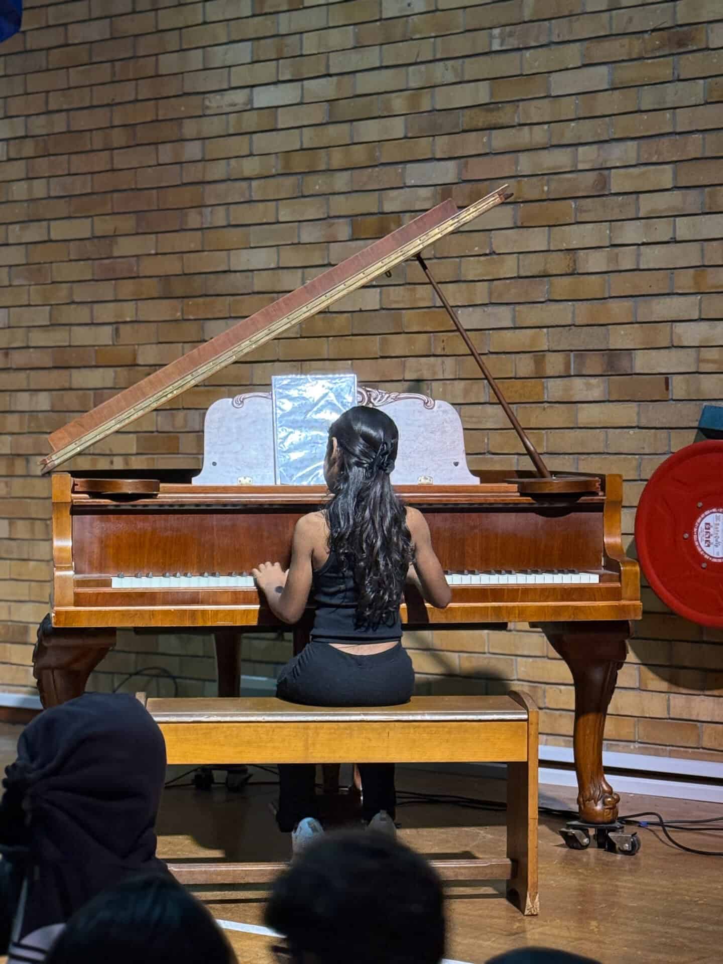A Camps Bay Primary learner performing on the grand piano in the school hall