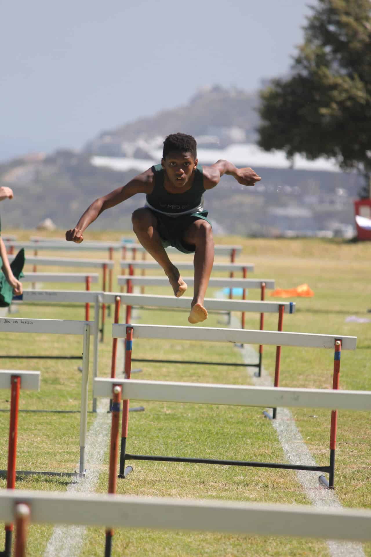 A Camps Bay Primary athlete clearing hurdles at the school athletics day