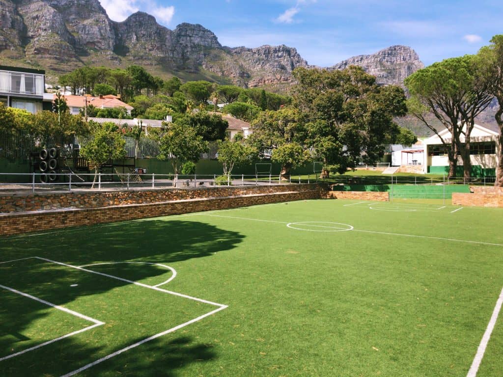 The astroturf soccer field at Camps Bay Primary, with the Twelve Apostles behind