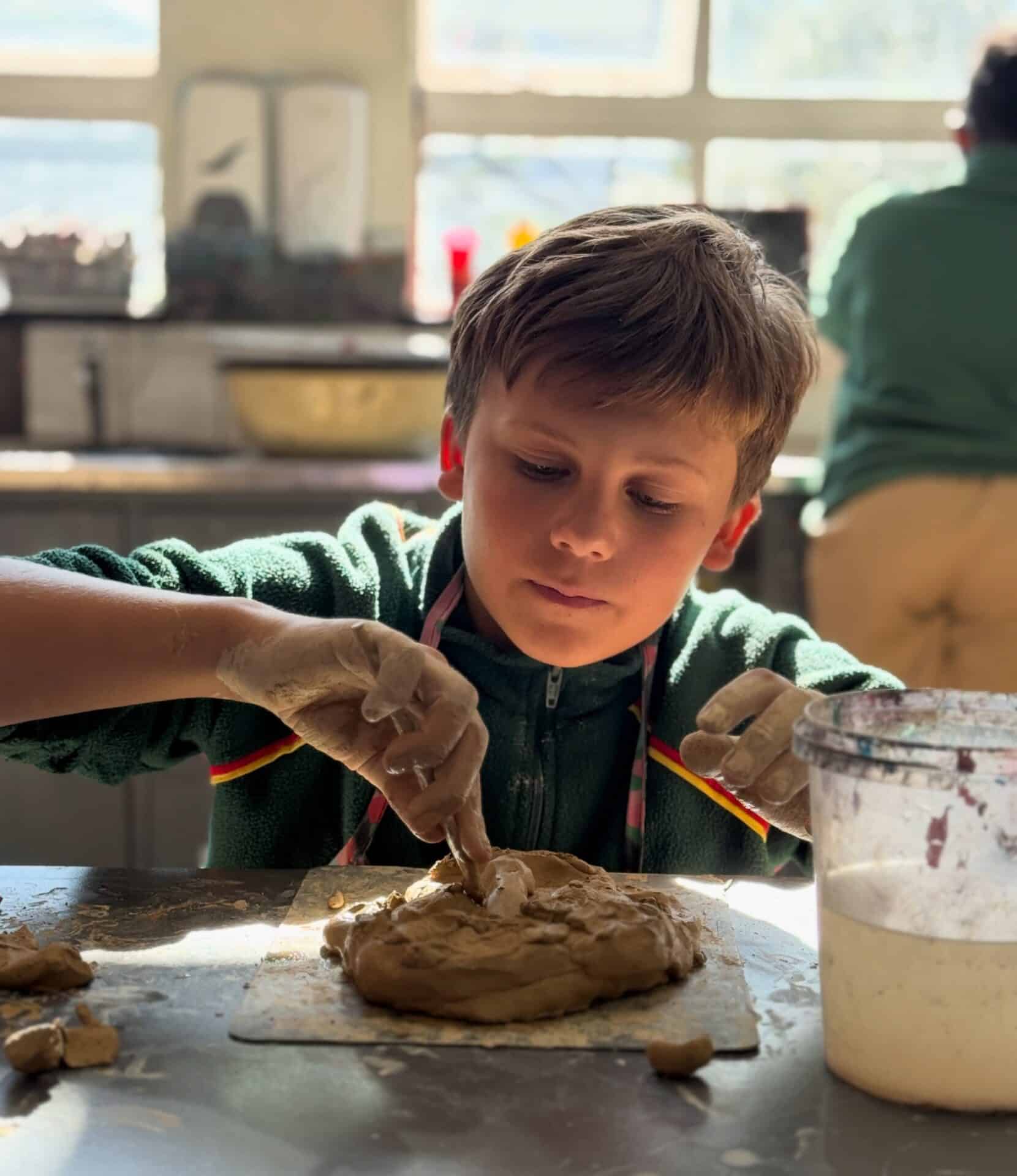 A learner shaping clay in an art lesson