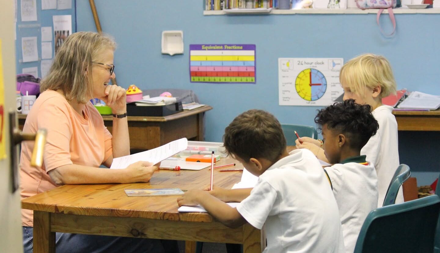 A learning support teacher working with a small group of young learners